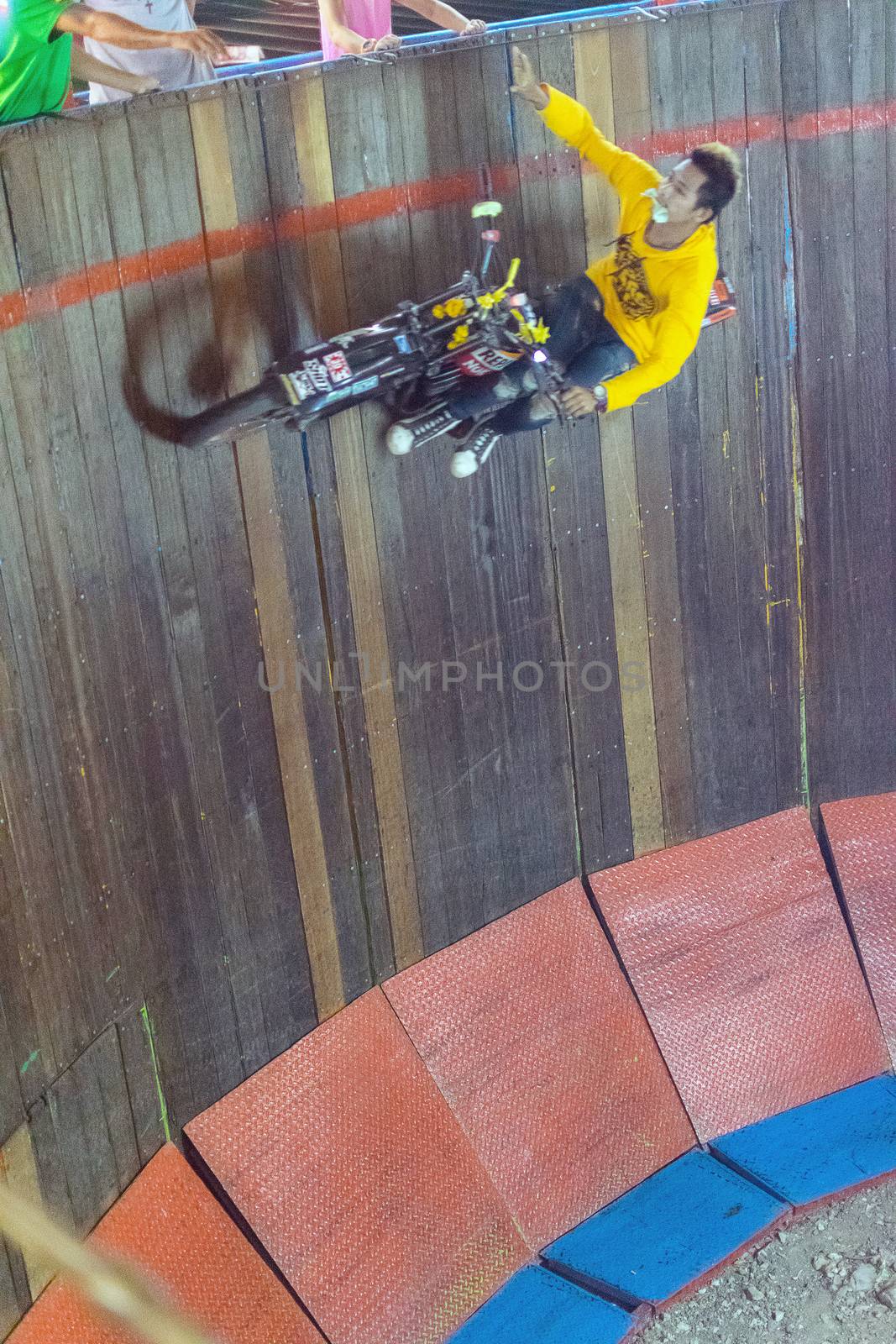 Bangkok, Thailand - January 10, 2016 : Unidentified asia rider motorcycle extreme show by climb and run on the circle wooden wall in a temple festival.