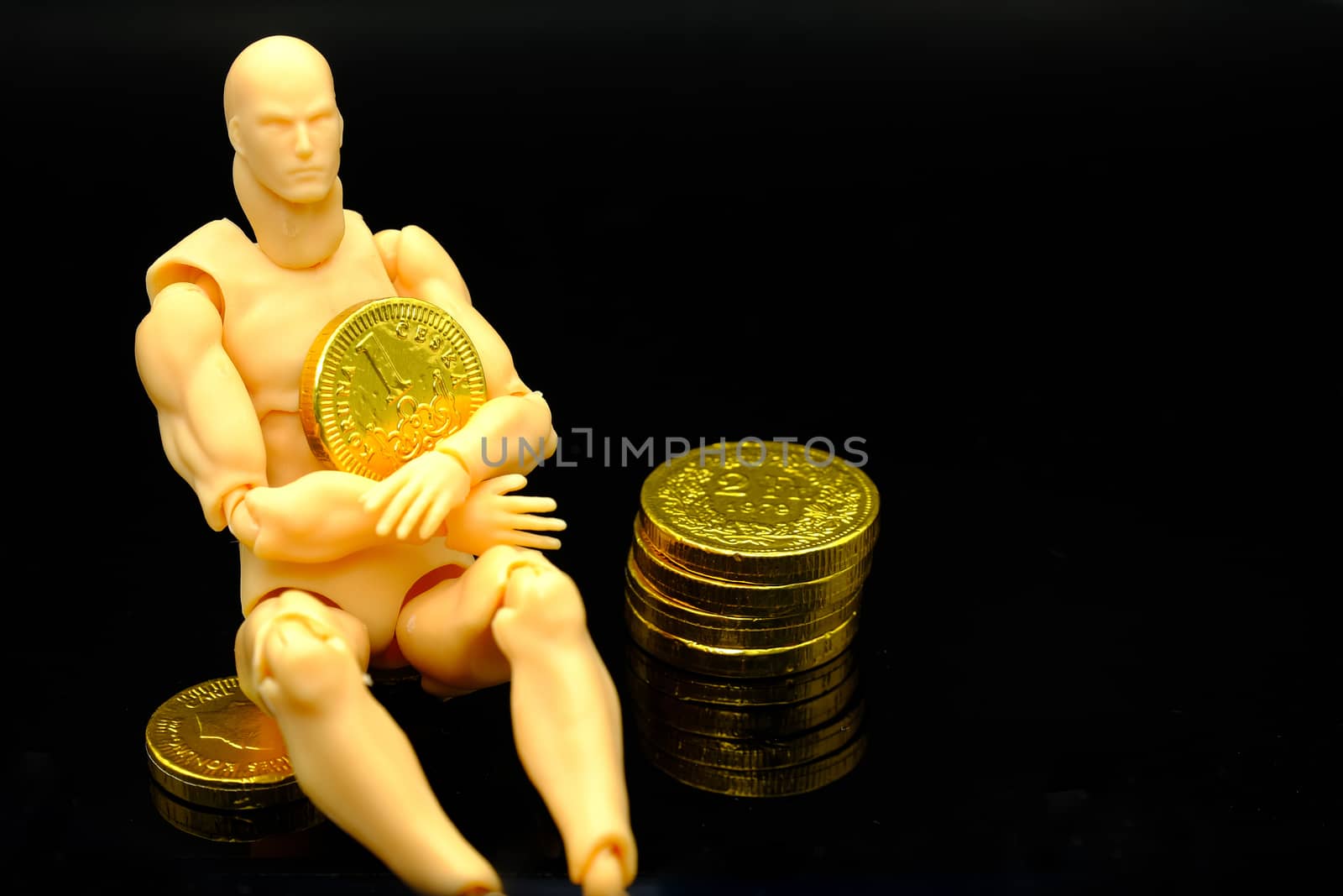 a conceptual pic of a male modle holding a (chocolate candy) gold coin