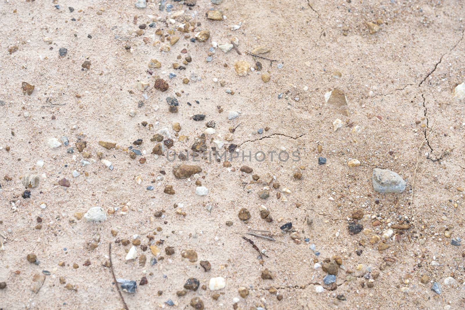 Fine and coarse gravels, pepbles, and small pieces of rock covering a path of dried river bed. Surface background.
