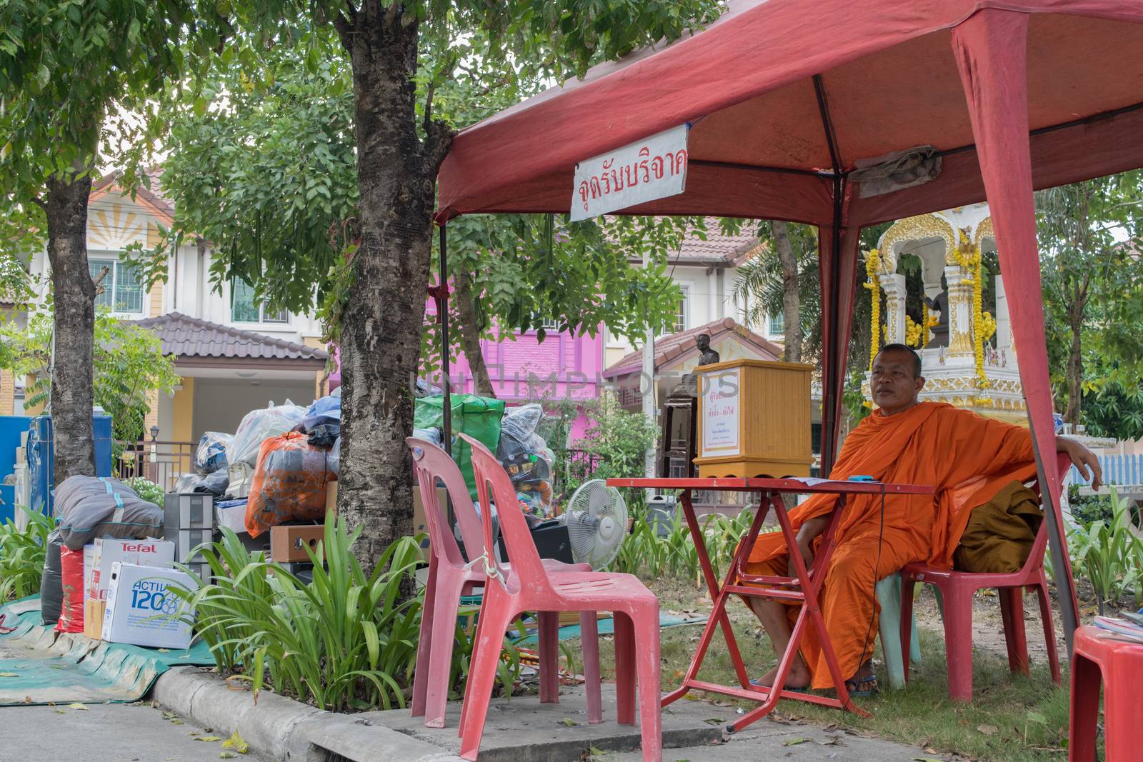 Bangkok, Thailand - October 14, 2015 : Thai monk volunteer waiting for donation at village in Don Mueang district.