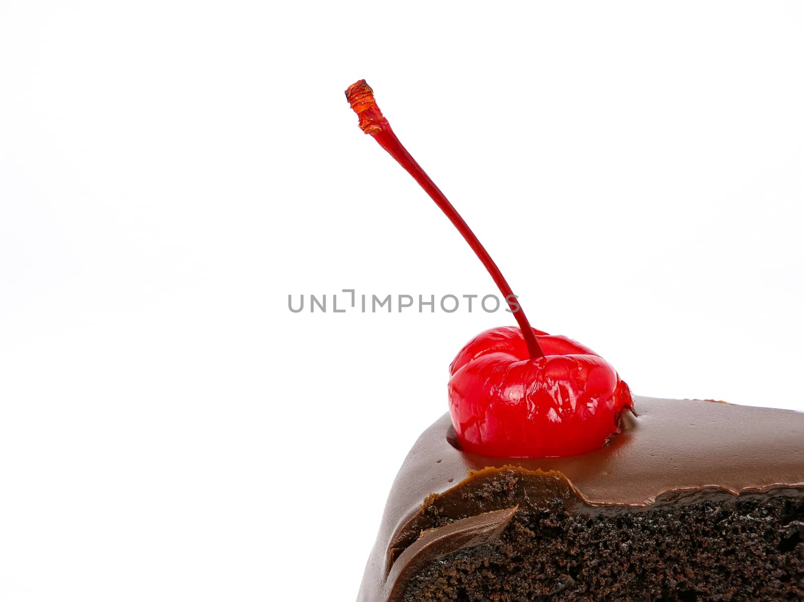 Side view shot of a slice of chocolate cake with cherries and cream filling and chocolate fudge (black forest cake) , isolated on white background