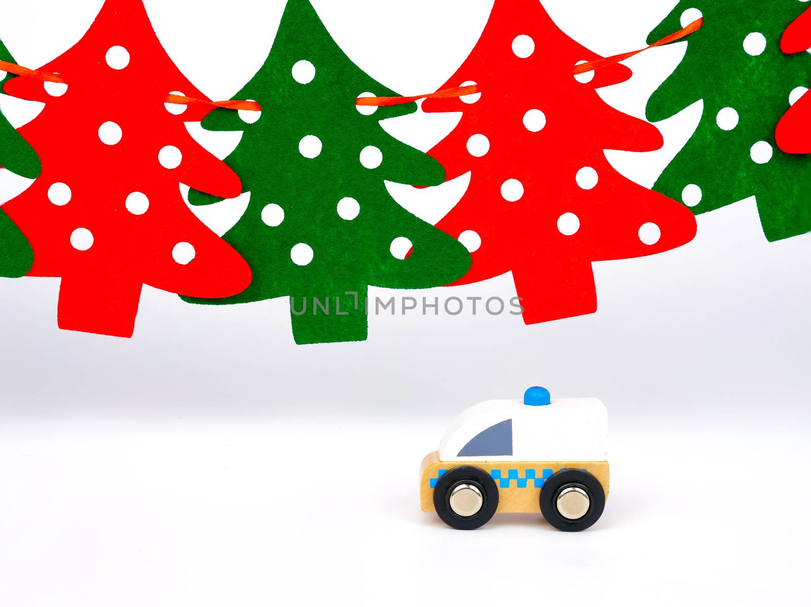 toy ambulance, red and green pine trees background, emergency service during holiday seasons concept