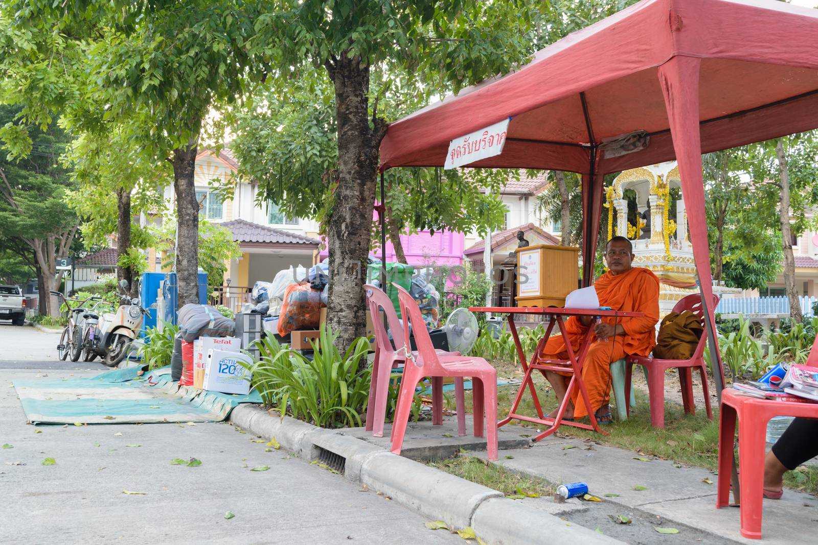 Bangkok, Thailand - October 14, 2015 : Thai monk volunteer waiting for donation at village in Don Mueang district.