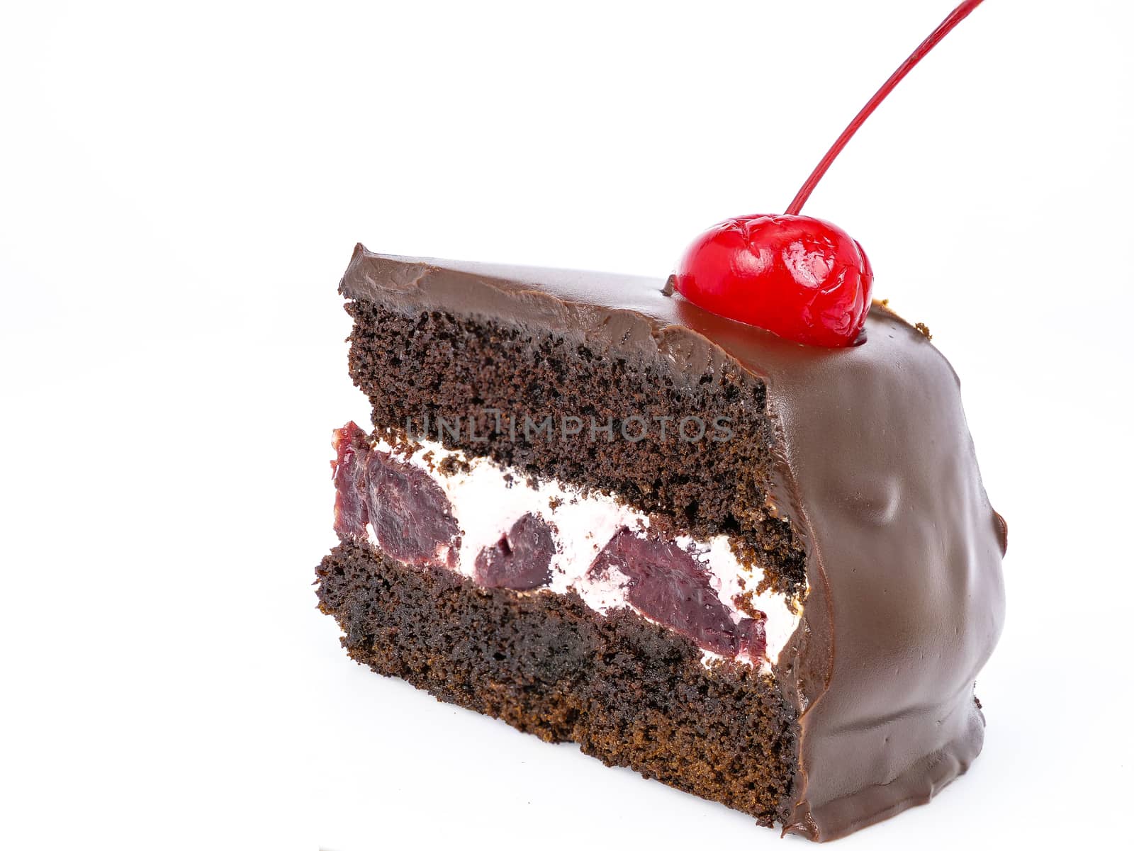 Side view shot of a slice of chocolate cake with cherries and cream filling and chocolate fudge (black forest cake) , isolated on white background