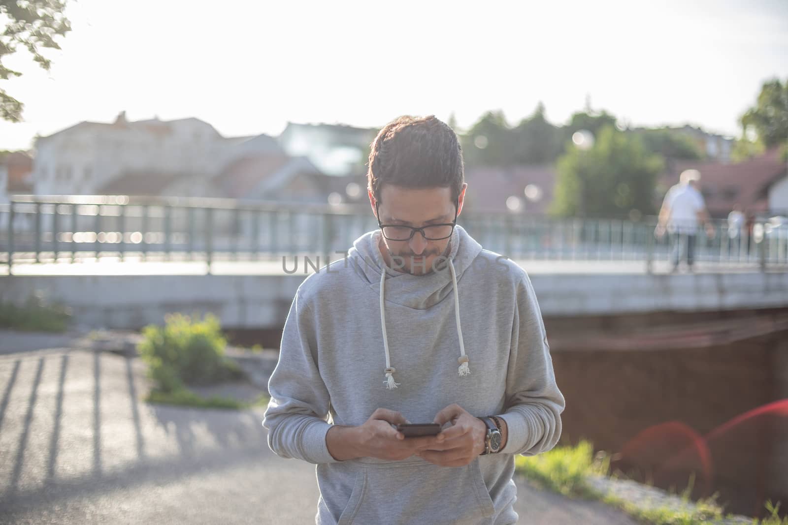 Man on smartphone in park, back light by adamr