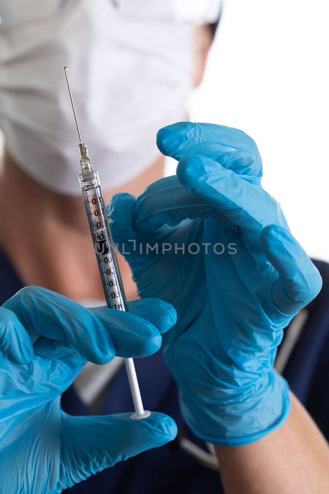 Doctor or Nurse Holding Medical Syringe with Needle.