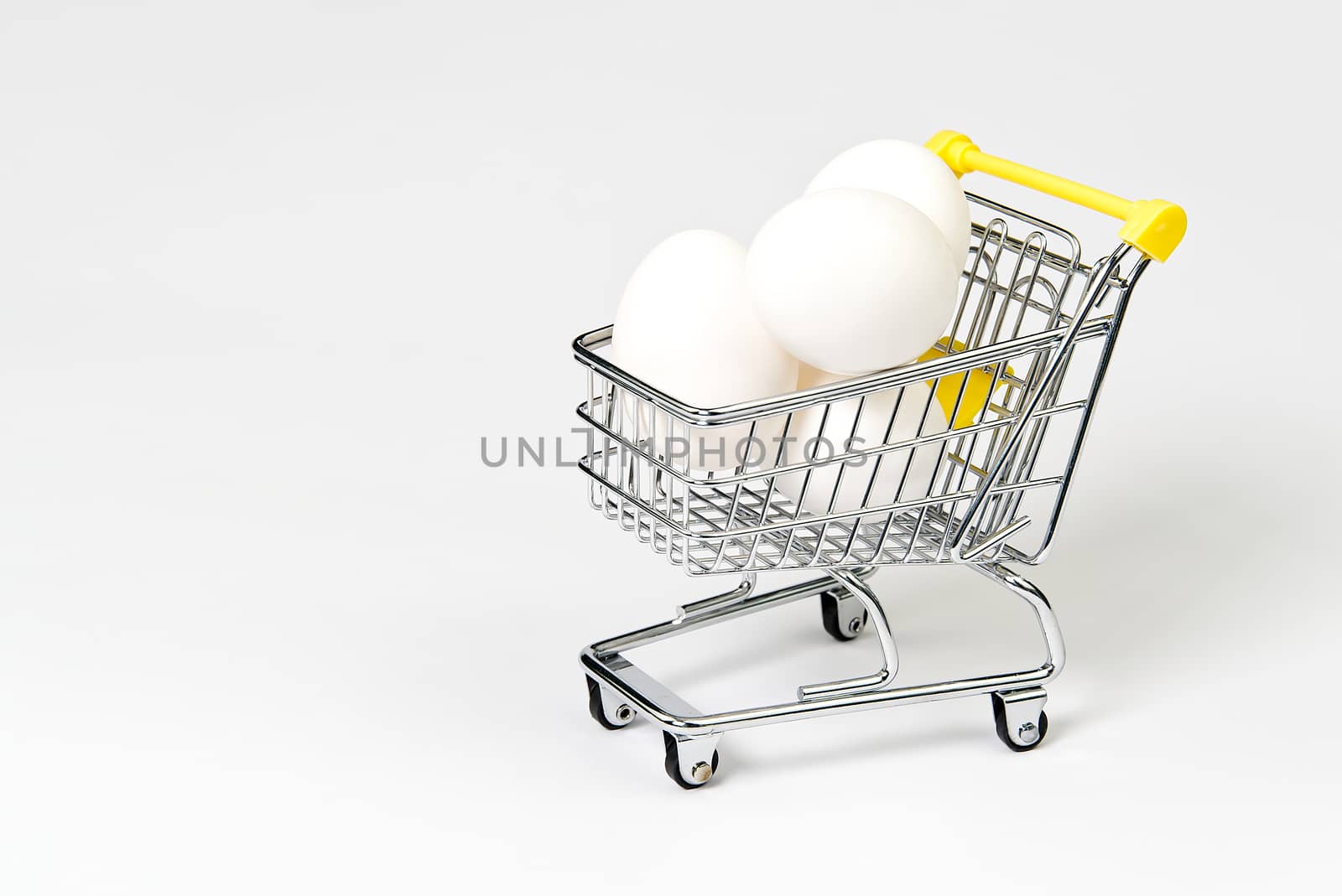 chicken white eggs in a shopping cart. isolated on white