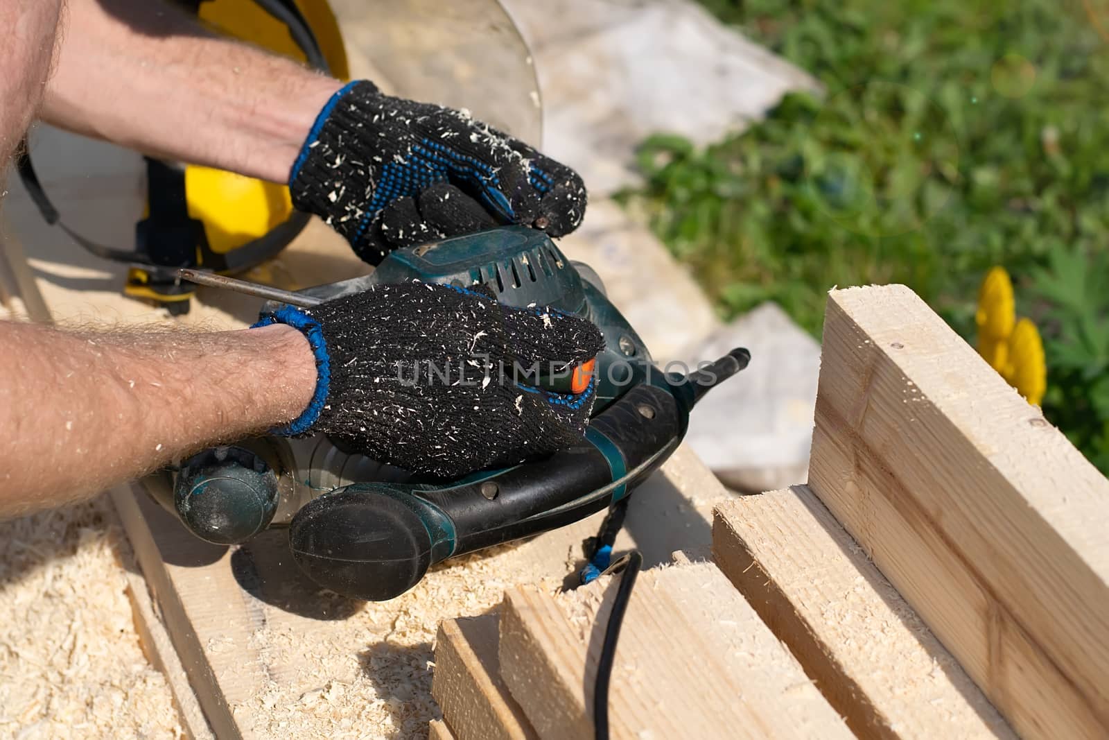 a master, craftsman, carpenter repairs an old broken electric tool for processing lumber