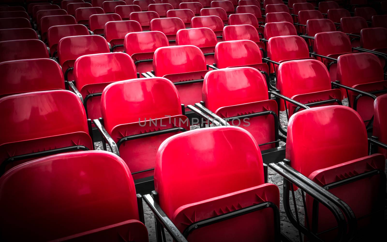 Empty plastic red chairs In outdoor theater in sunny day. Close Up.