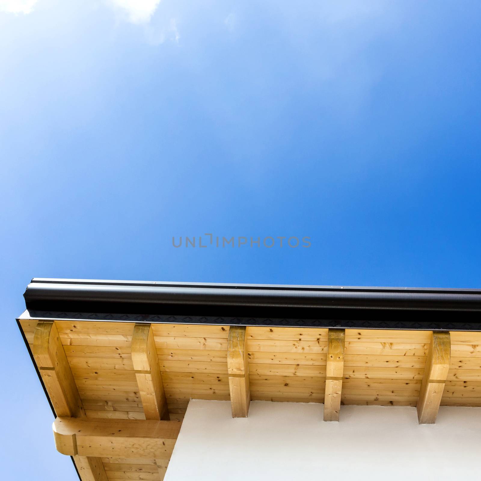 Corner of house with wooden beams and gutter by germanopoli