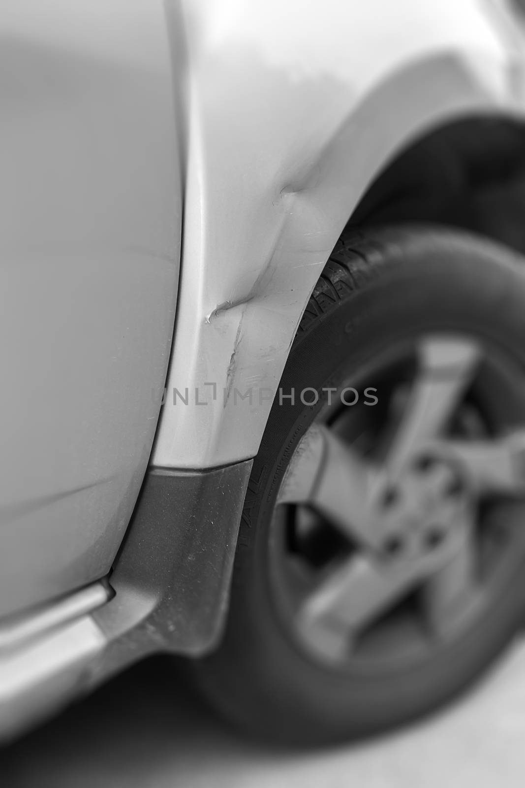 Dents on the car caused by the accident. Shallow depth of field.