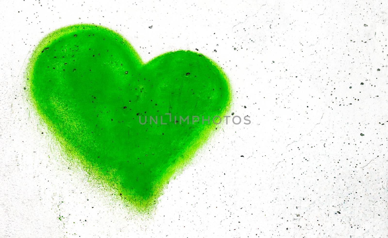 Green heart shaped on grungy wall background with copy space