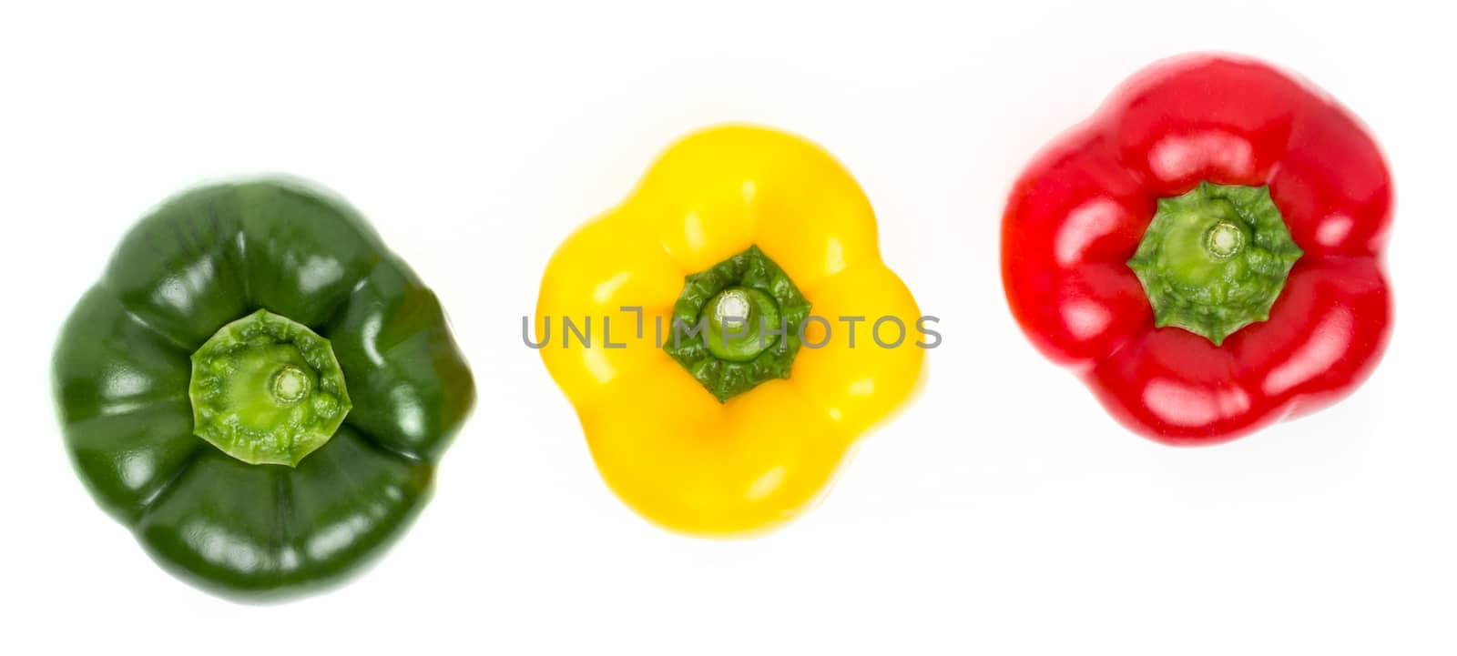 Three peppers of different colors lie in a row on a white backgr by germanopoli