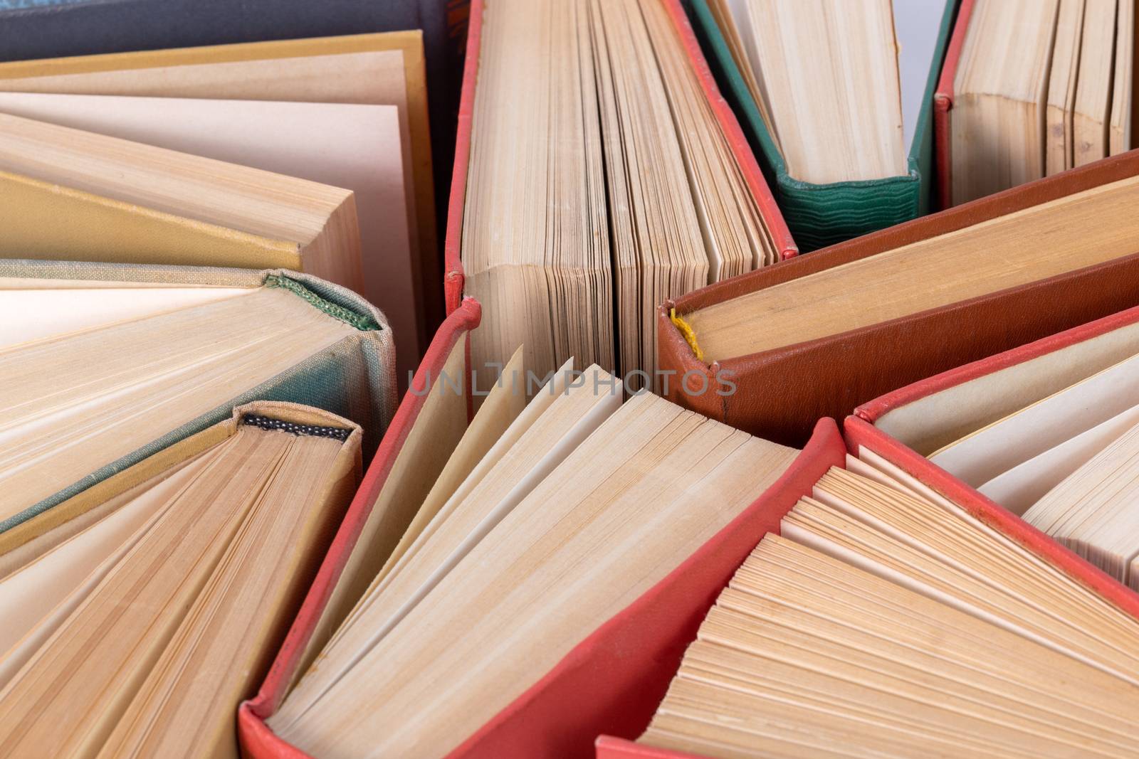 Many different old hardcover physical books close-up background with selective focus and blur.