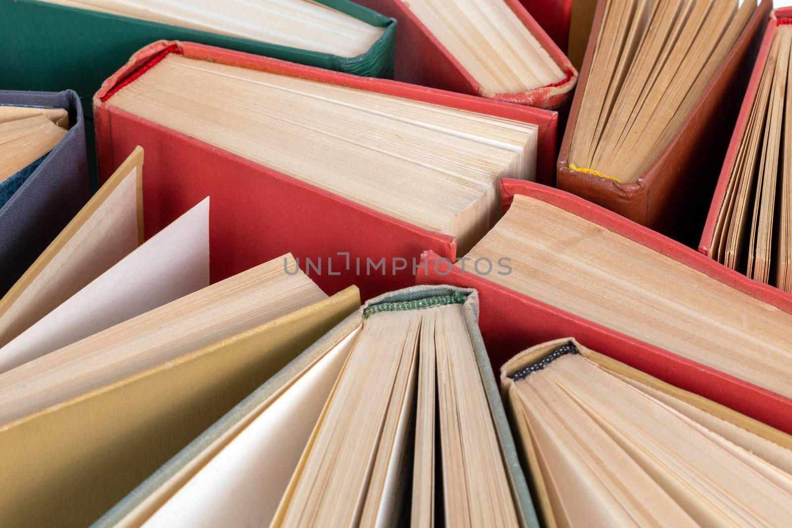 Many different old hardcover physical books close-up background with selective focus and blur.