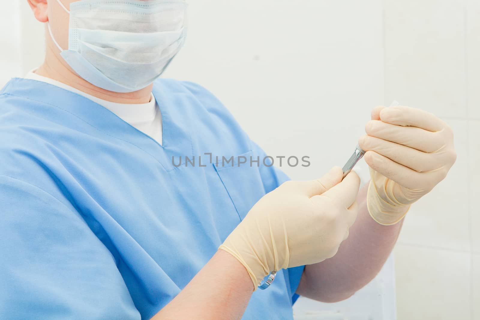 A medical worker holds a syringe in his gloves against a light background. close-up