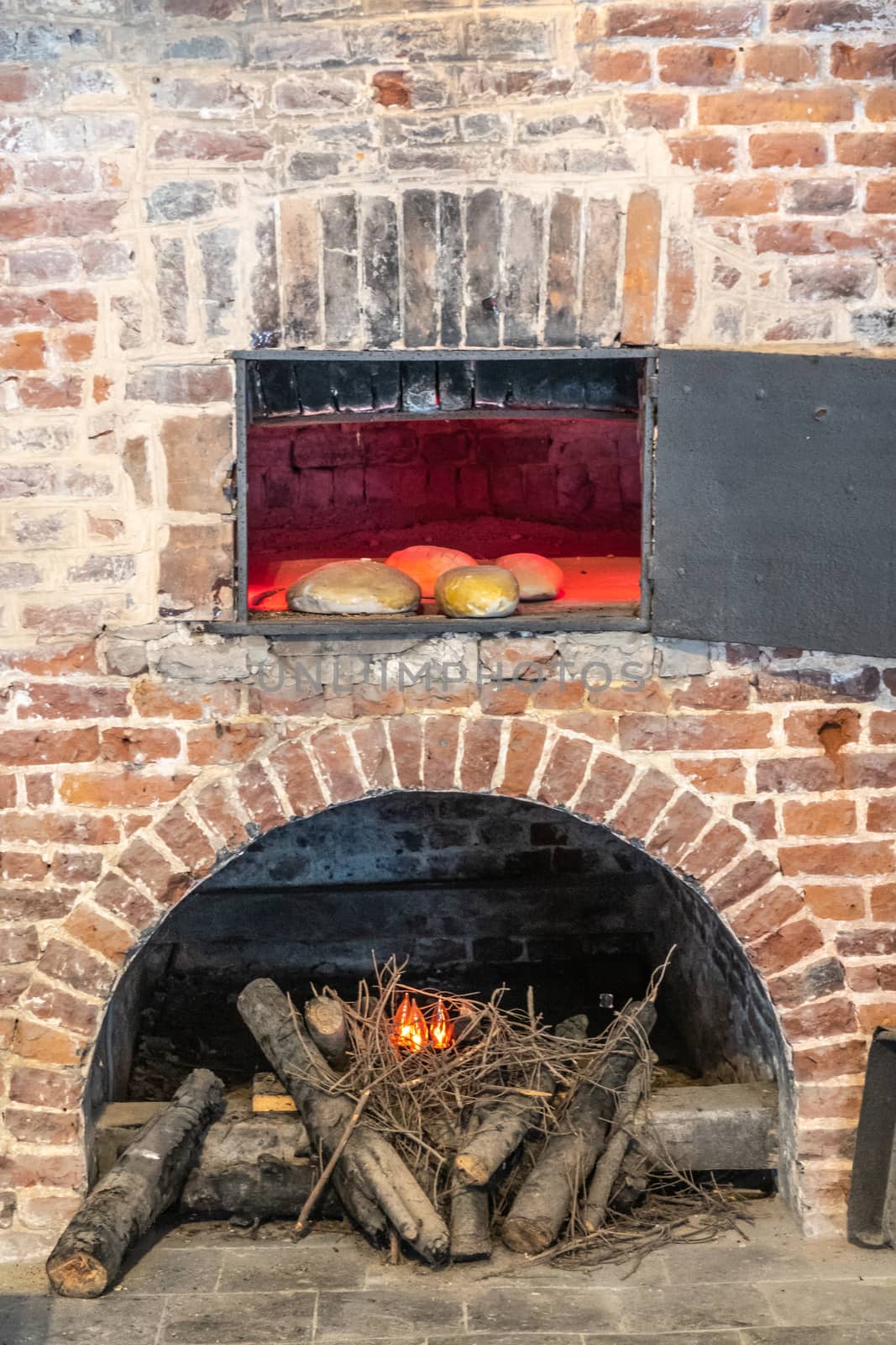 Dinant, Belgium - June 26, 2019: Inside Citadelle. Part of historic bakery with focus on one of the bread baking ovens, set in brick wall and wood fire.