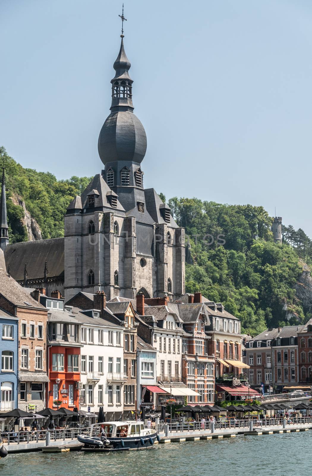 Notre Dame Church behind businesses in Dinant, Belgium. by Claudine