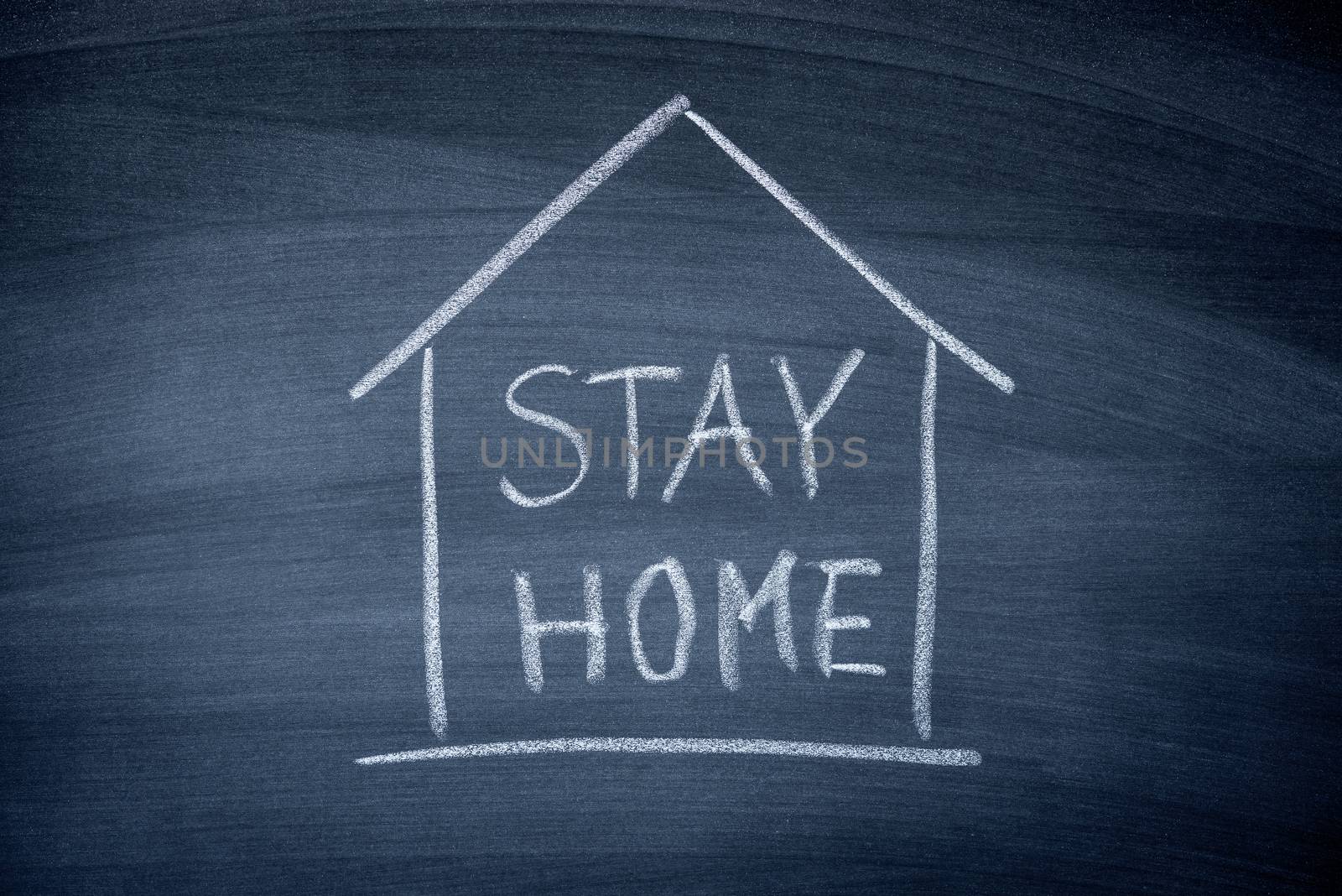 Stay at Home sign write on black chalkboard , prevent COVID-19 corona virus  spreading