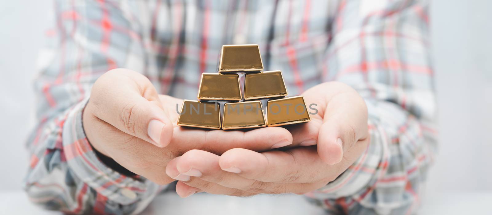 worker man hand holding gold bar stack.