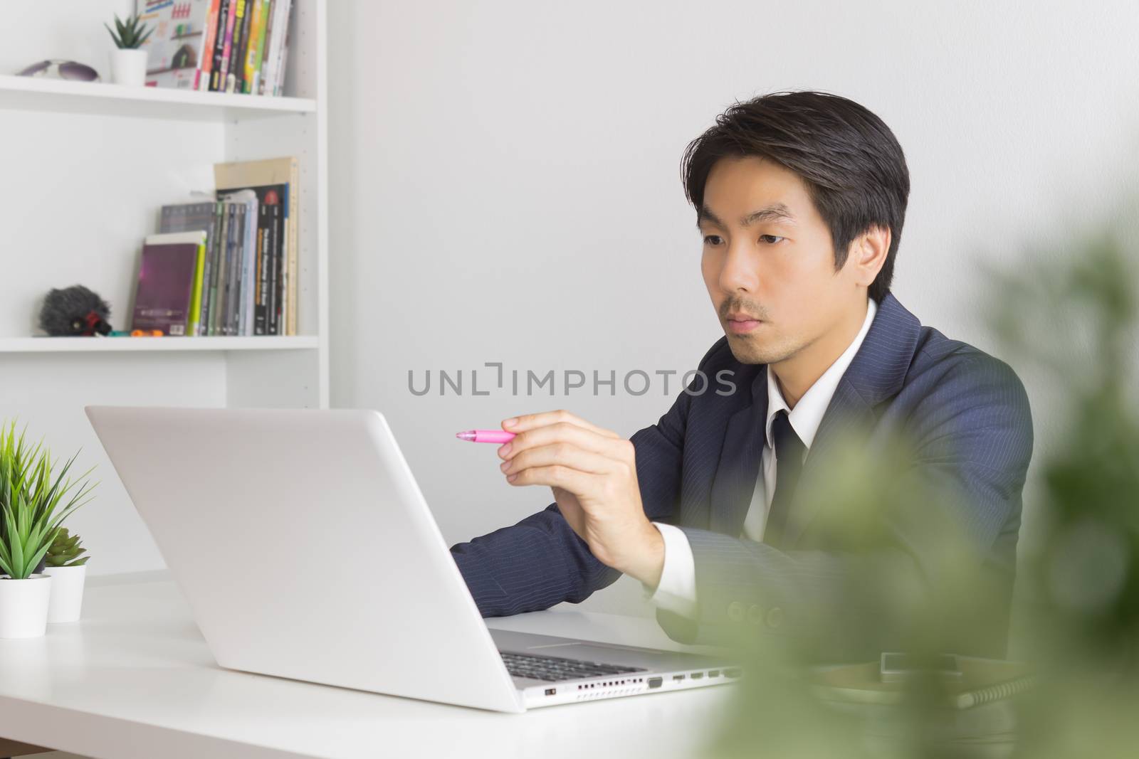 Asian Financial Advisor or Asian Consulting Businessman Seriously Customer Recommend in front of Laptop. Asian financial advisor or Asian consulting businessman contact with customer via internet
