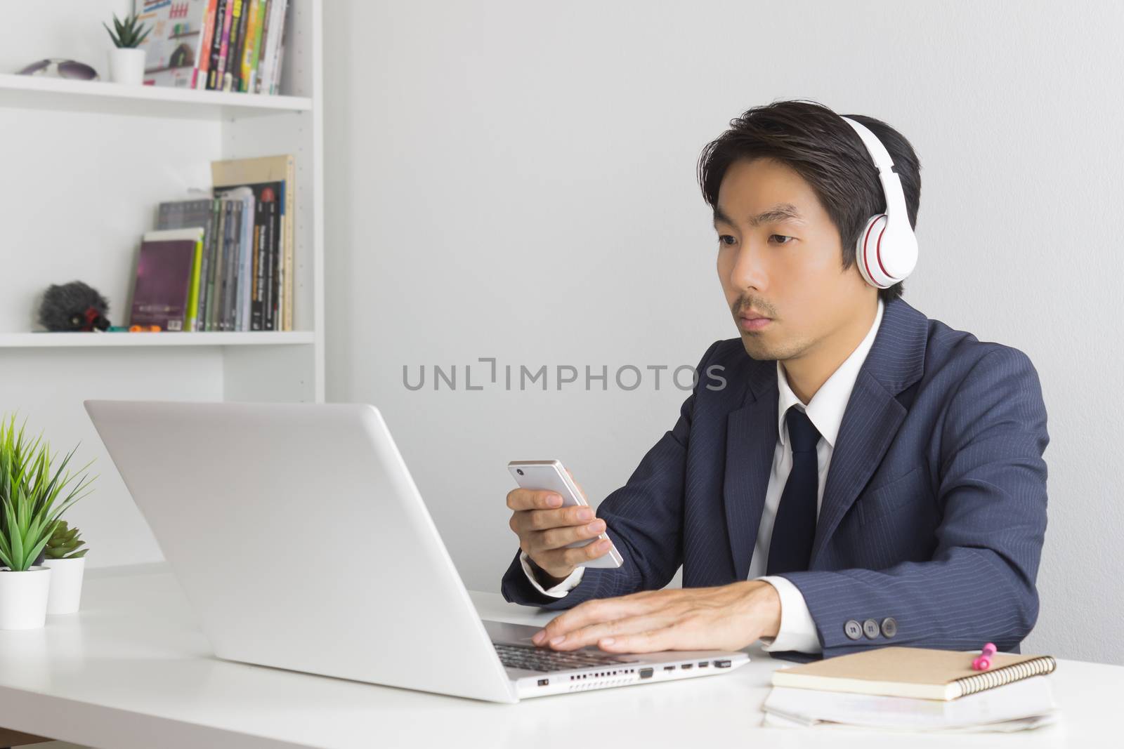 Asian Man Call Center Answer Customer Questions by Smartphone an by steafpong