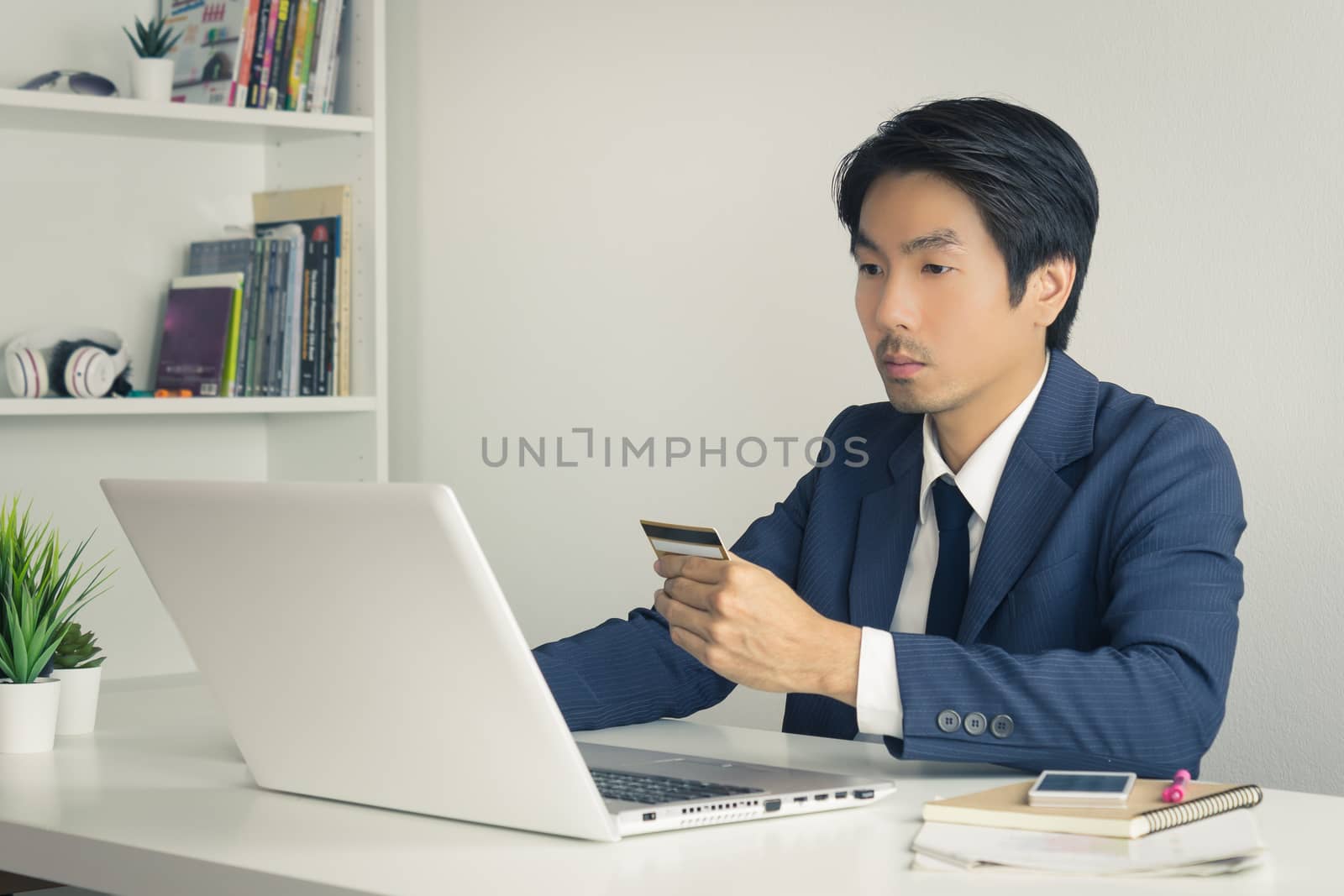Asian Businessman in Suit Shopping Online by use Credit Card. Asian Businessman enter security code from credit card to shopping online system