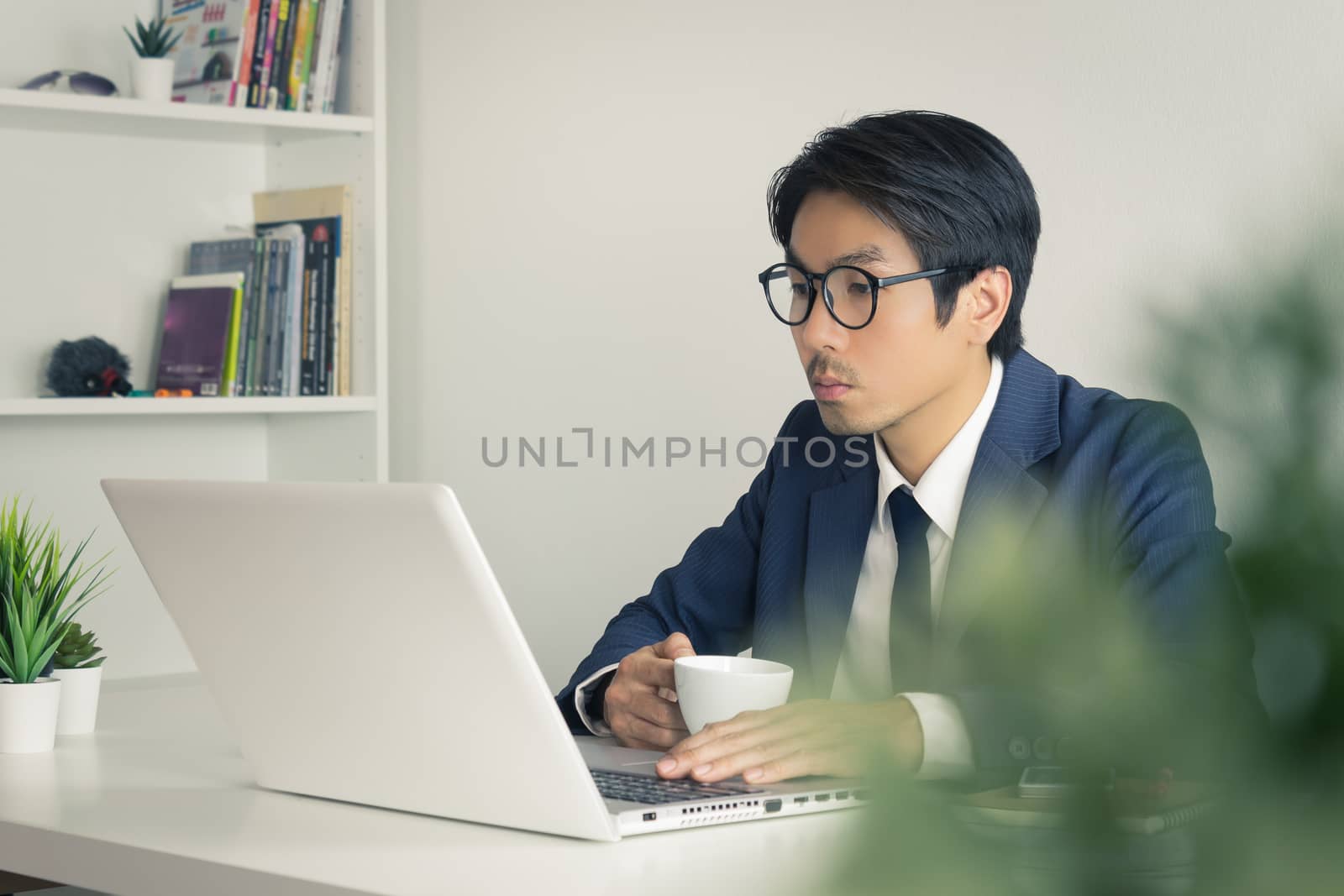 Asian Businessman Wear Eyeglasses Seriously Analyze Financial Da by steafpong