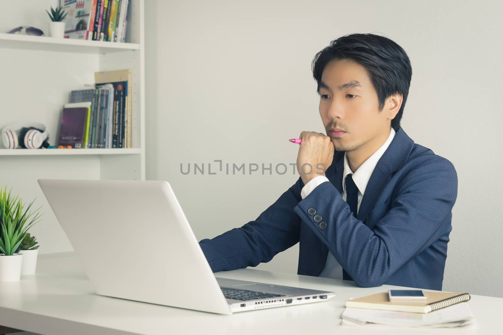 Asian Financial Advisor or Asian Consulting Businessman in Suit Thinking and Calculate. Asian Financial Advisor or Asian Consulting Businessman contact with customer via internet