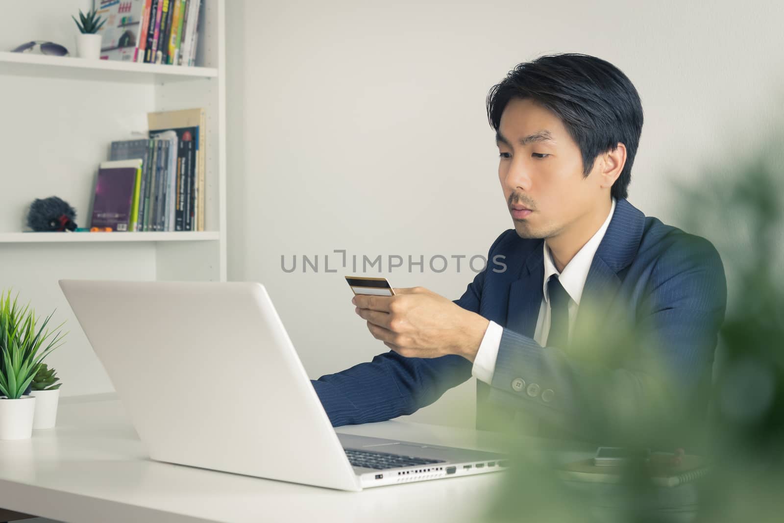 Asian Businessman Fill Credit Card Information for Online Shopping in front of Laptop. Asian Businessman paying credit card online
