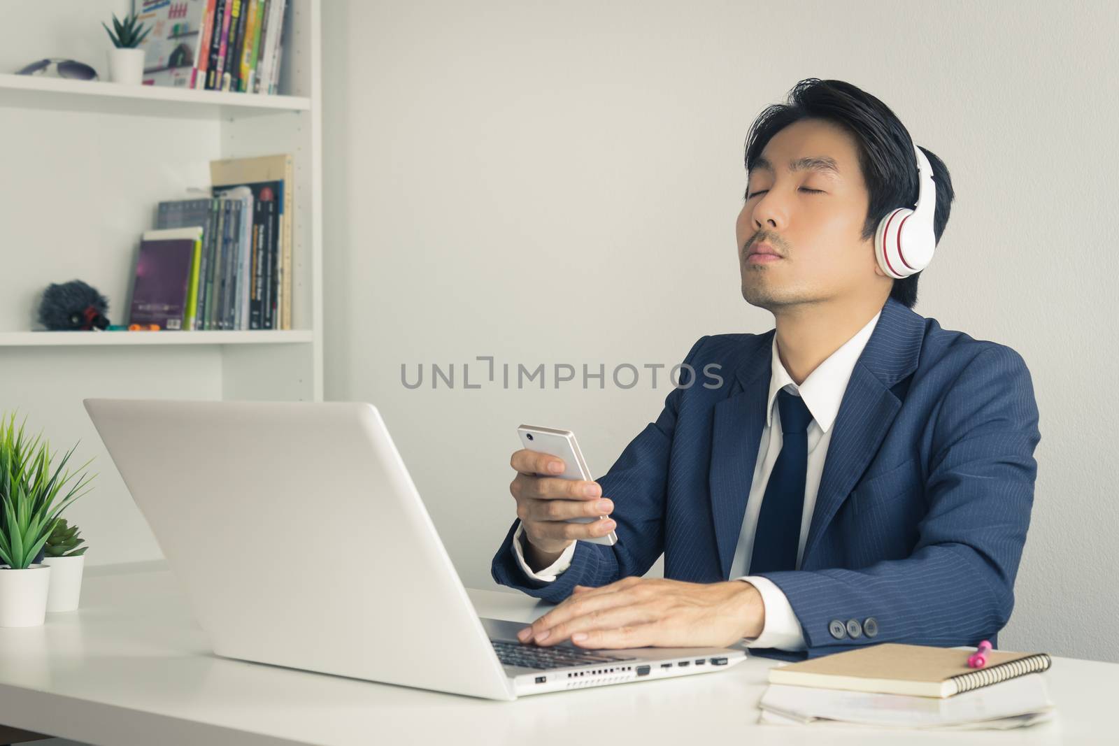 Asian Businessman Listen to Music by Bluetooth Technology in Sma by steafpong