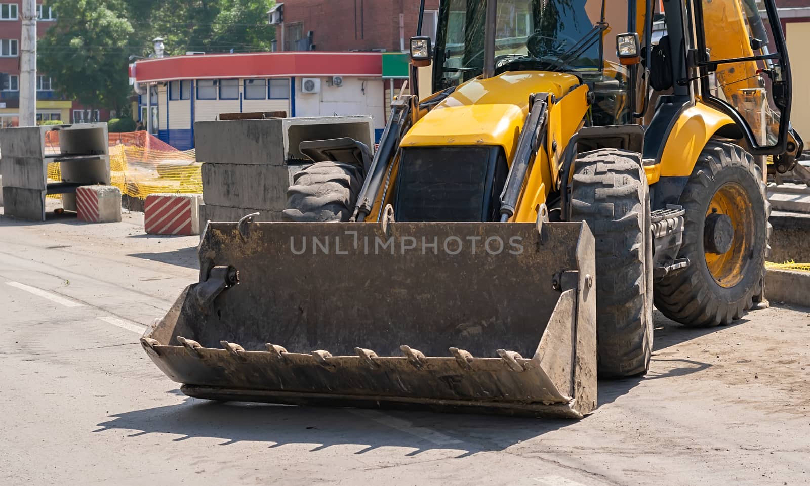 excavator on a city street where the road is being repaired by jk3030