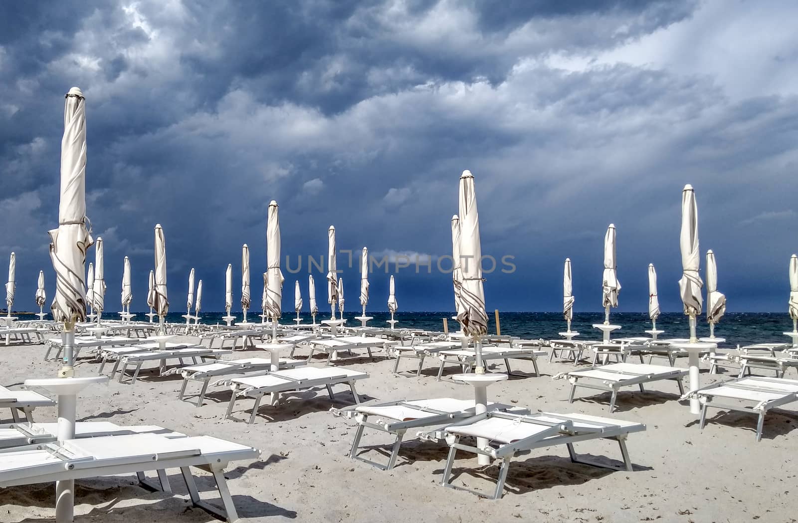 Dark and stormy sky, with gray clouds on the blue sea and a litt by robbyfontanesi