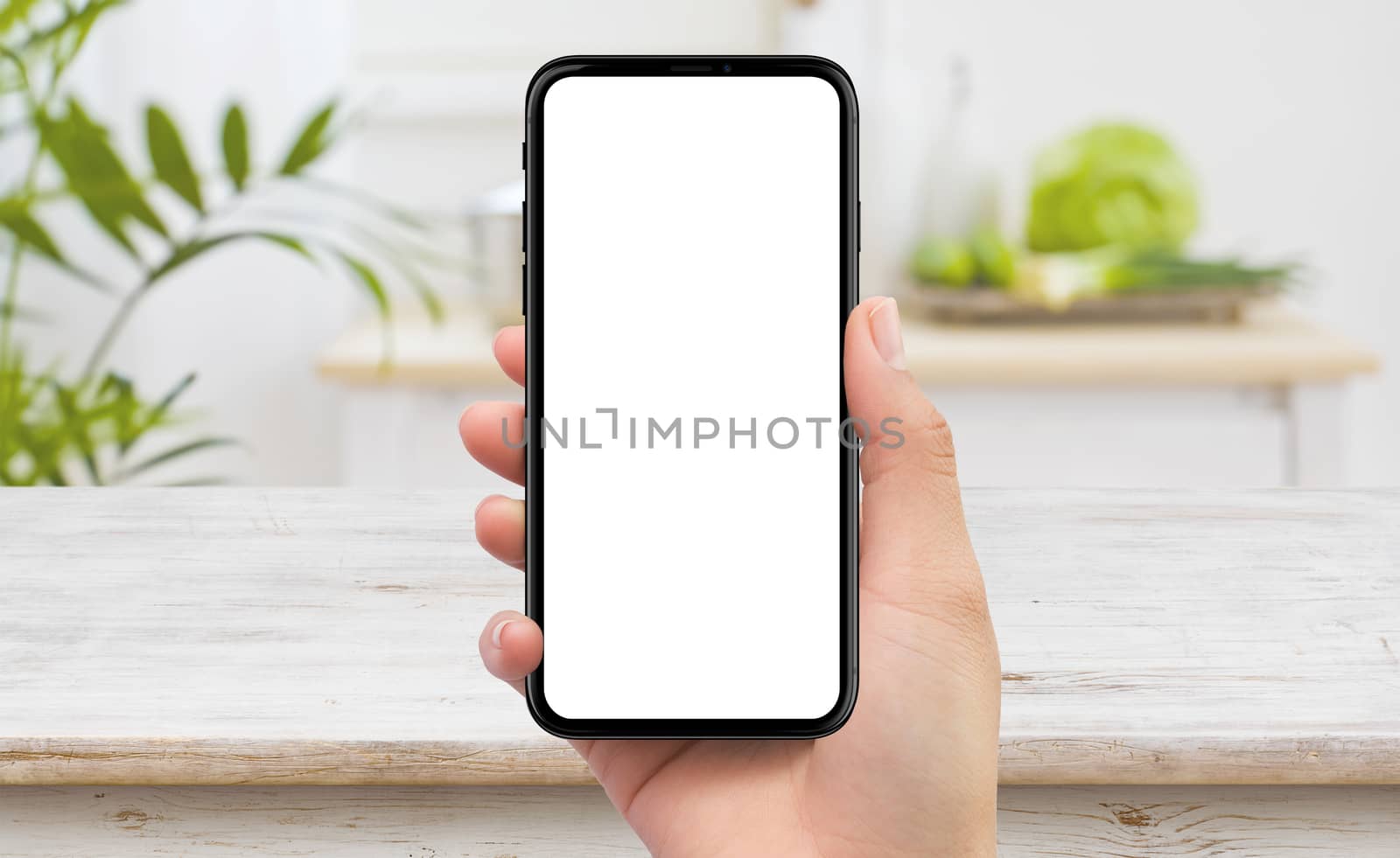 Isolated human right hand holding black mobile smart phone device mockup in kitchen