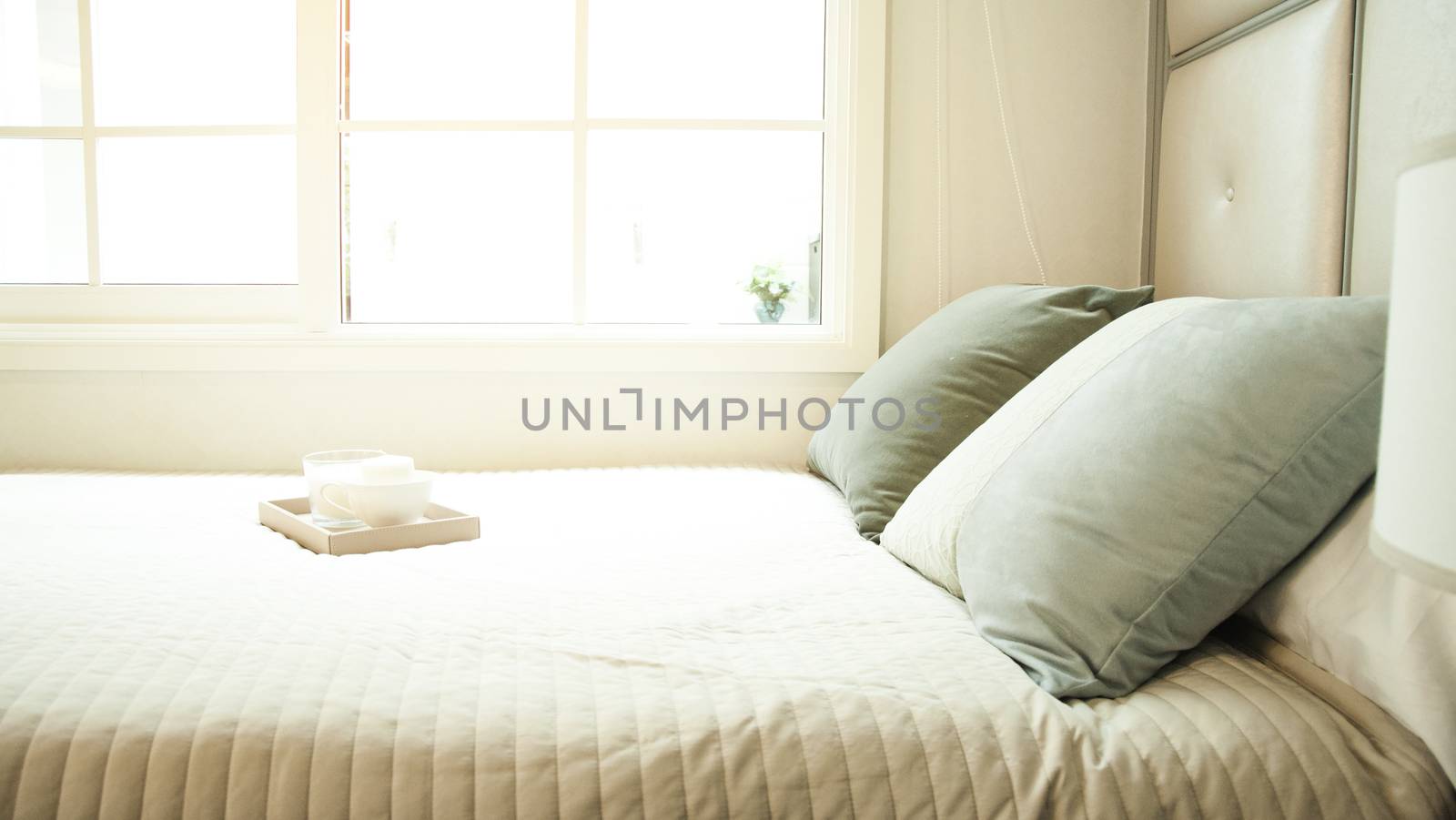 Rest,relax, interior, comfort and bedding concept - bed at home bedroom. Comfortable white bed. Bed maid-up with pillows and bed sheets in beauty room. 