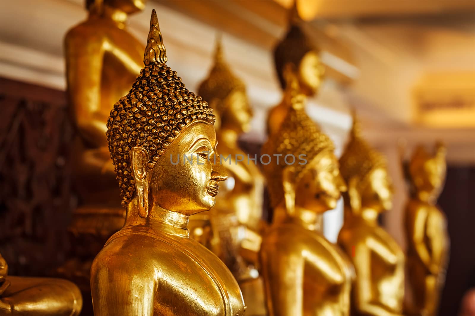Golden Buddha statues in buddhist temple by dimol