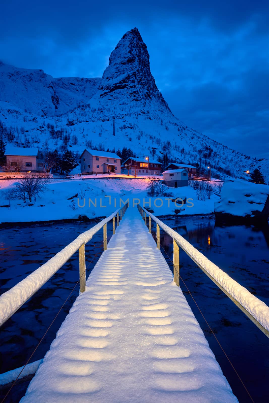 Bridge in Reine village covered with snow at night. Lofoten islands, Norway