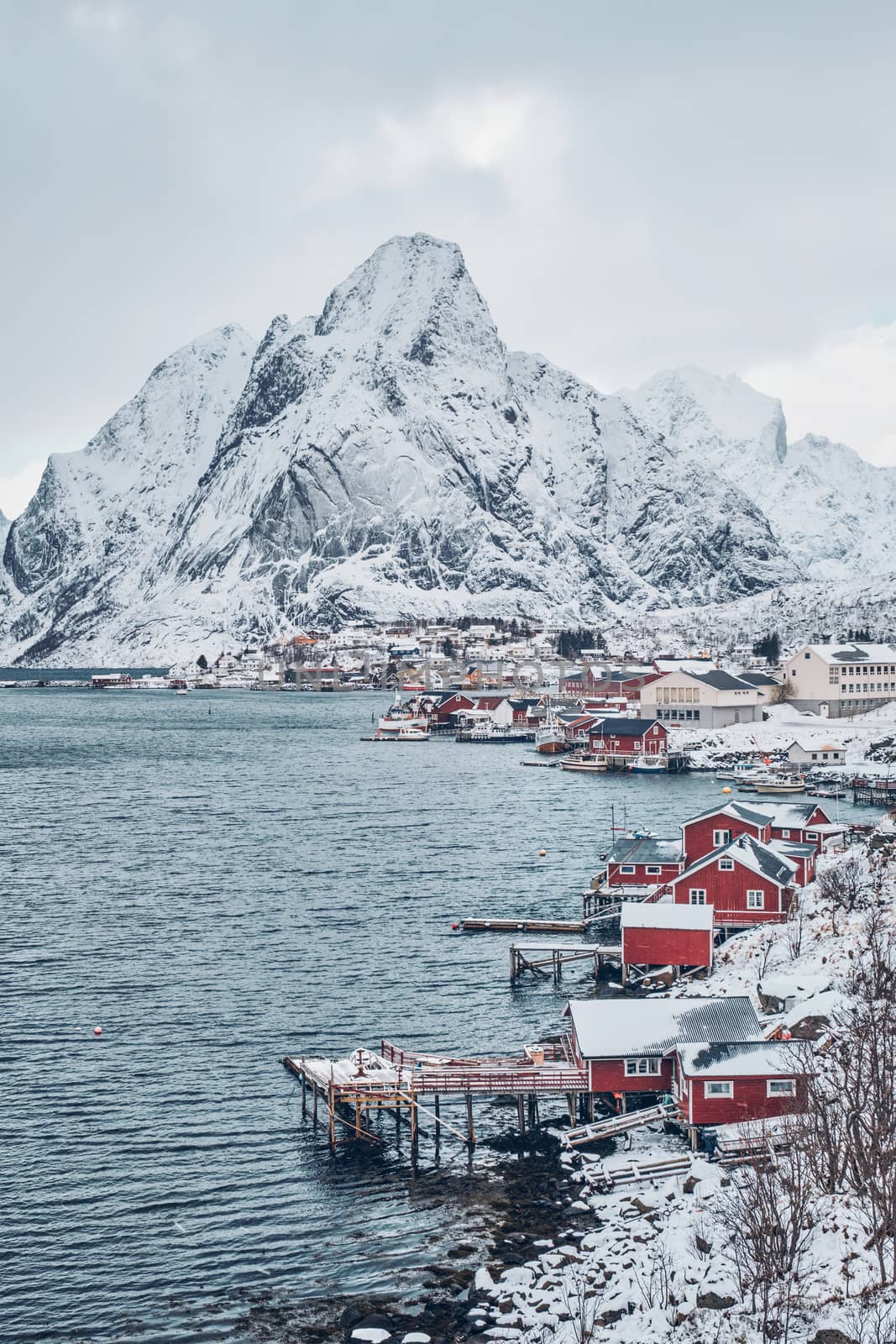 Reine fishing village on Lofoten islands with red rorbu houses in winter with snow. Norway