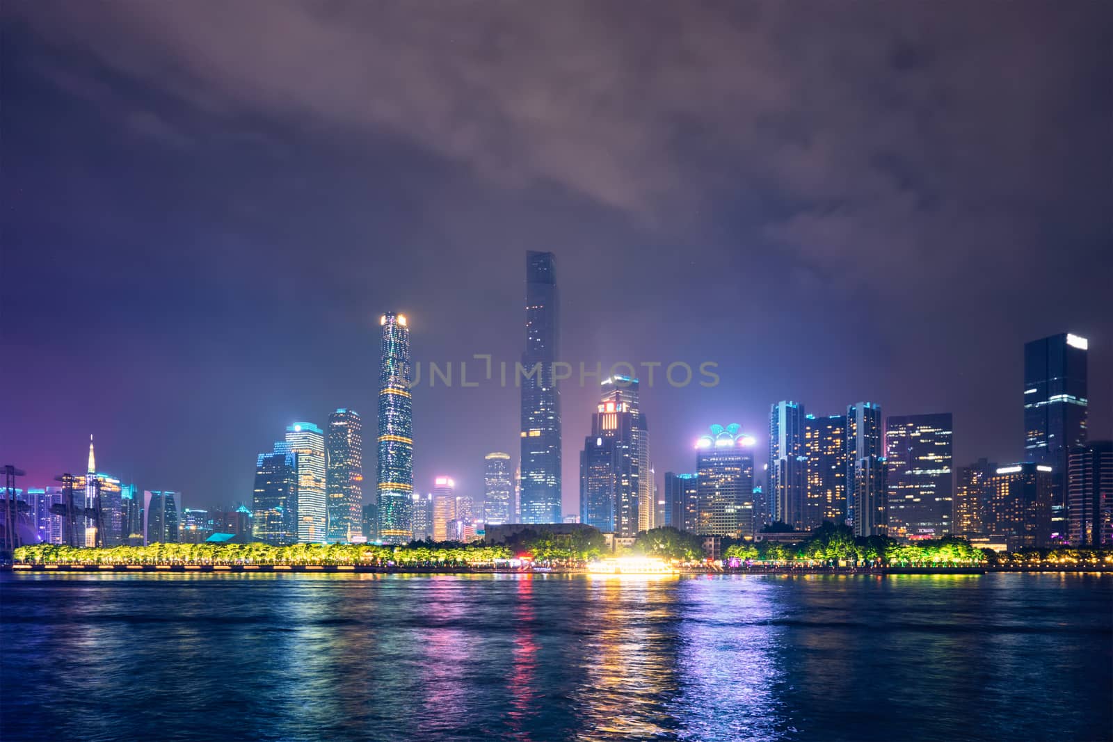 Guangzhou cityscape skyline over the Pearl River illuminated in the evening. Guangzhou, China