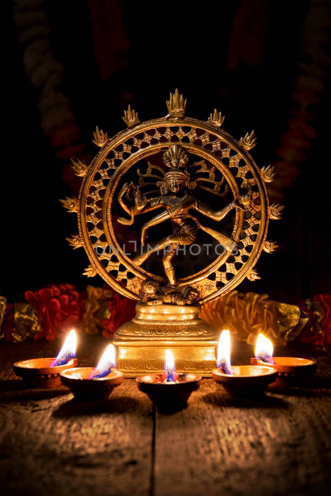 Maha Shivaratri or Diwali concept - Shiva Nataraja figurine with Diwali lights oil ghee candles, India