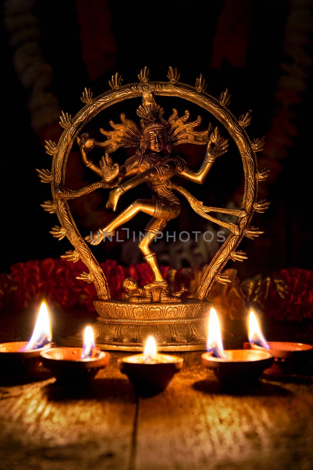 Maha Shivaratri or Diwali concept - Shiva Nataraja figurine with Diwali lights oil ghee candles, India