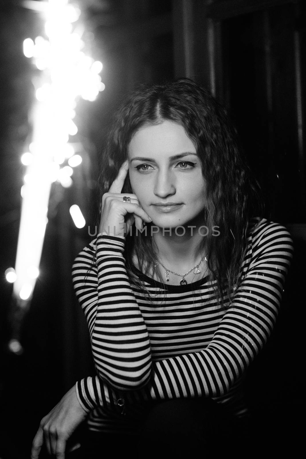 girl lit sparklers inside a wooden house late at night