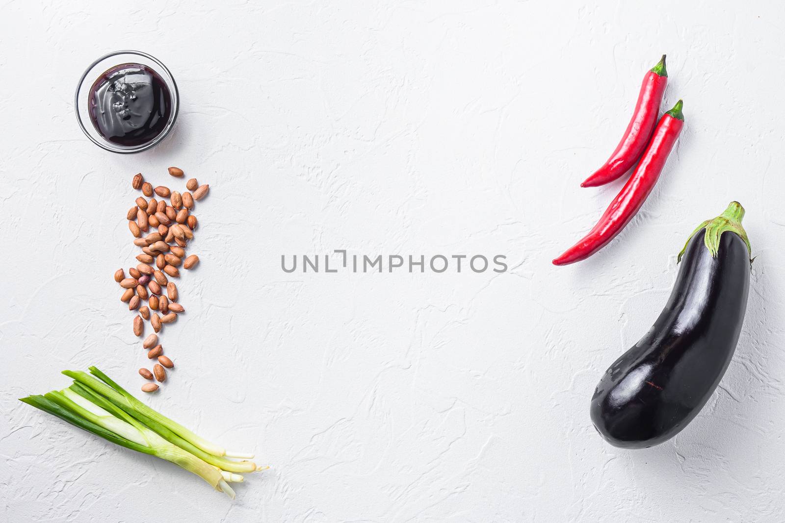 Ripe aubergine ingredients, for cooking or grill chili pepper, eggplant, sauce, nuts on white background top view space for text concept frame