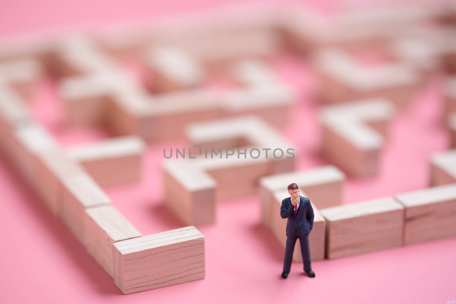 business miniature at the start point of puzzle maze wood block.