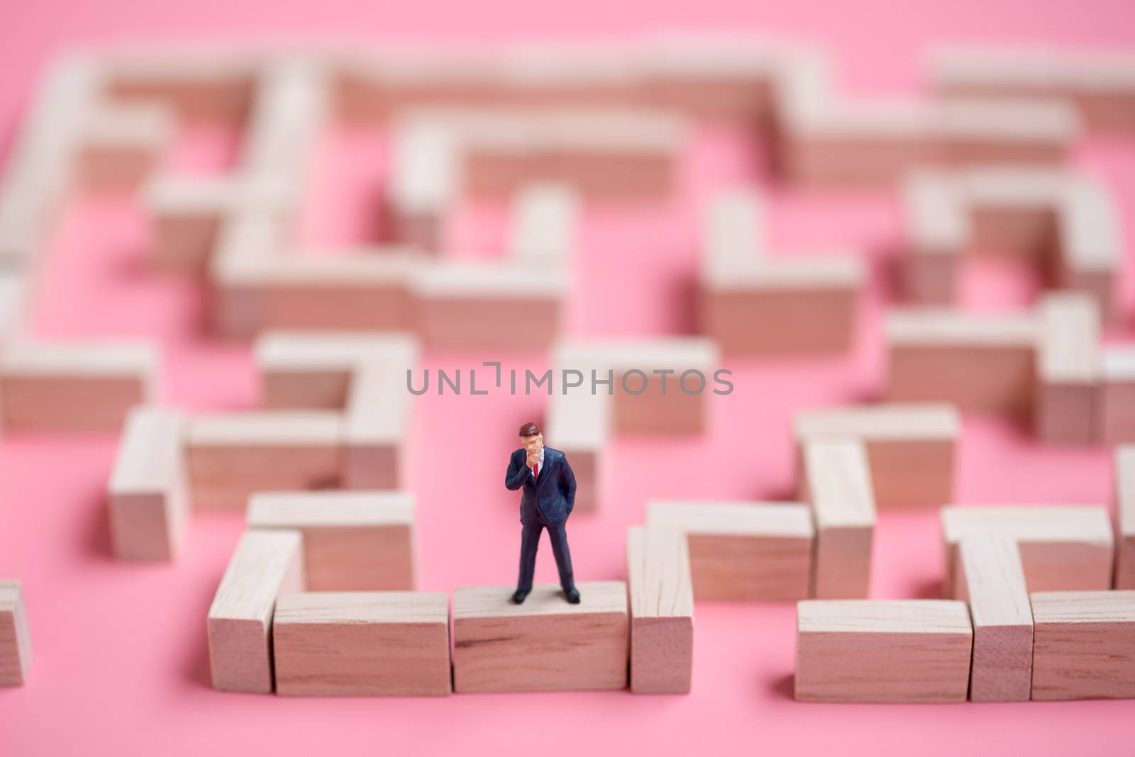 business miniature at the start point of puzzle maze wood block.