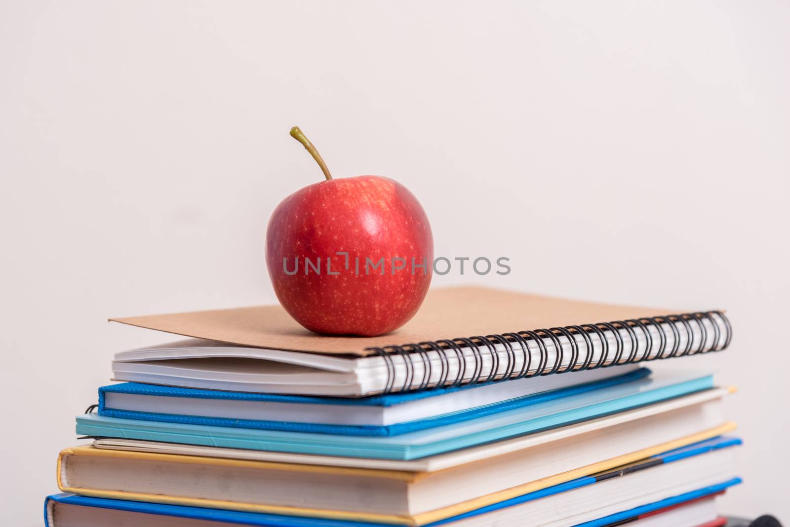 red apple on stack of book.