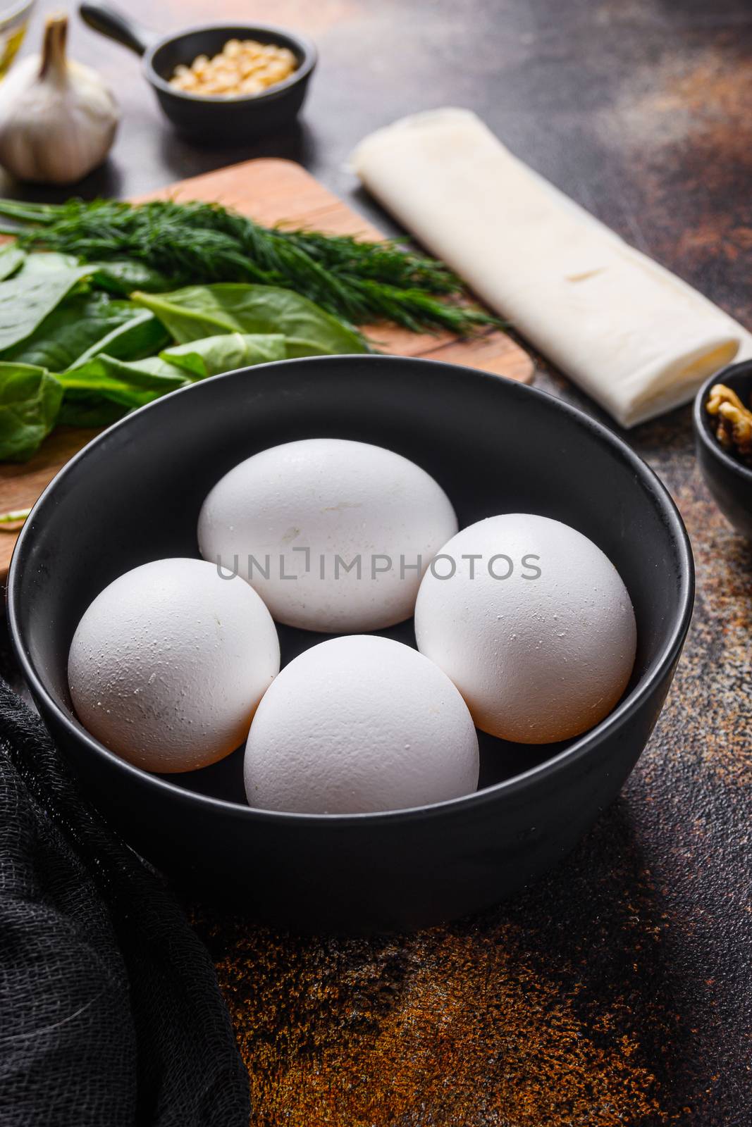 Chicken white eggs in black bowl side view. by Ilianesolenyi