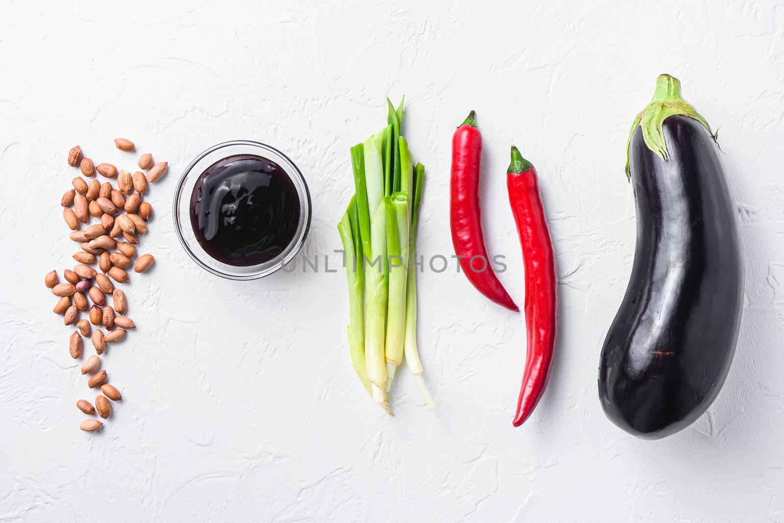 Ripe aubergine ingredients, for cooking or grill chili pepper, eggplant, sauce, nuts on white background top view