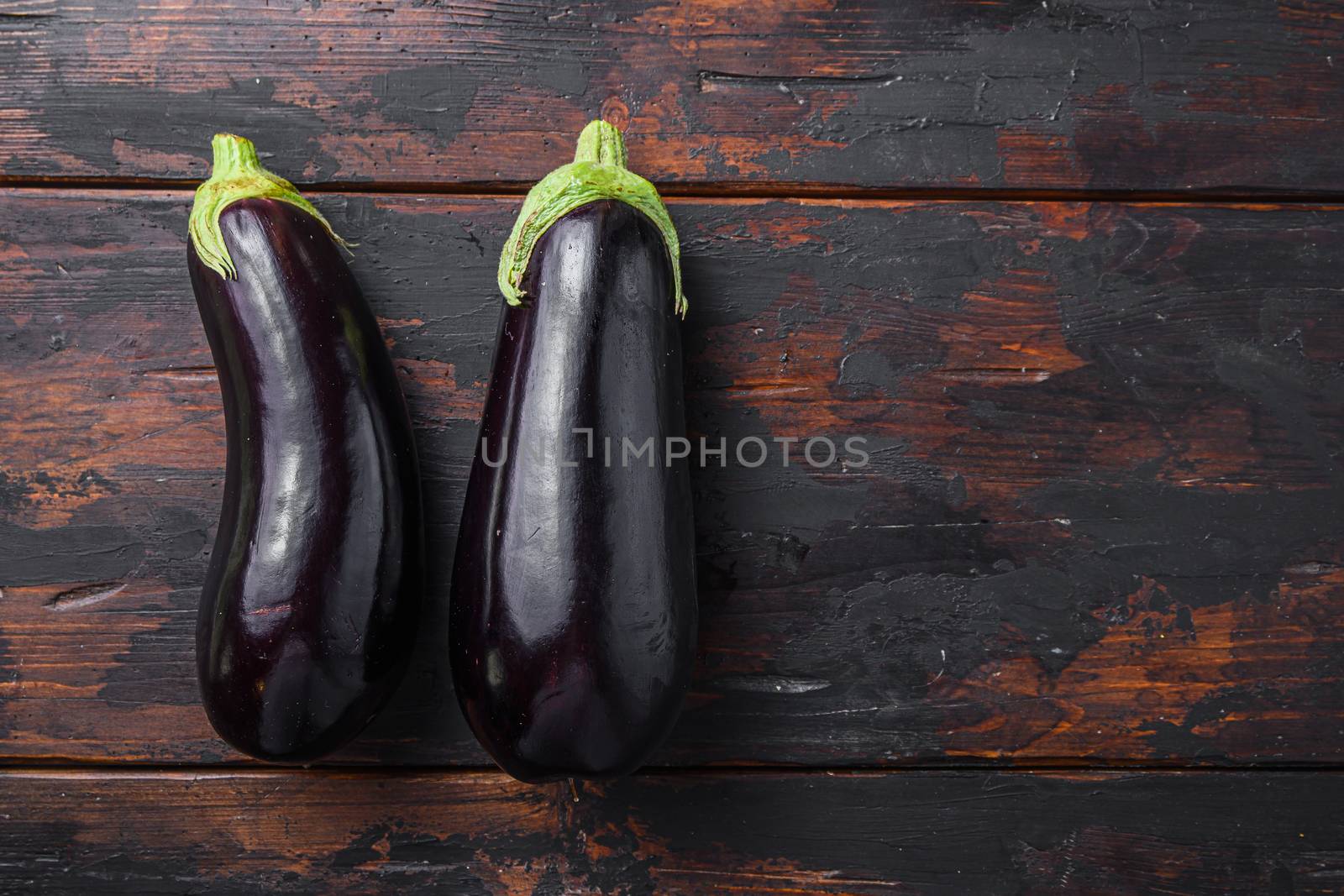 Fresh healthy raw Purple aubergine on a kitchen old dark wooden table. Top view, space for text