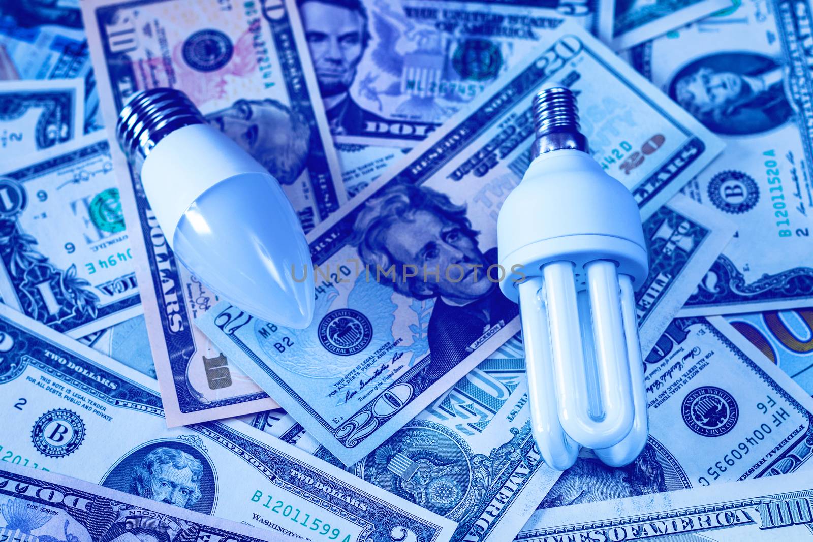 LED lamp on dollar bills background. The concept of saving money on electricity.